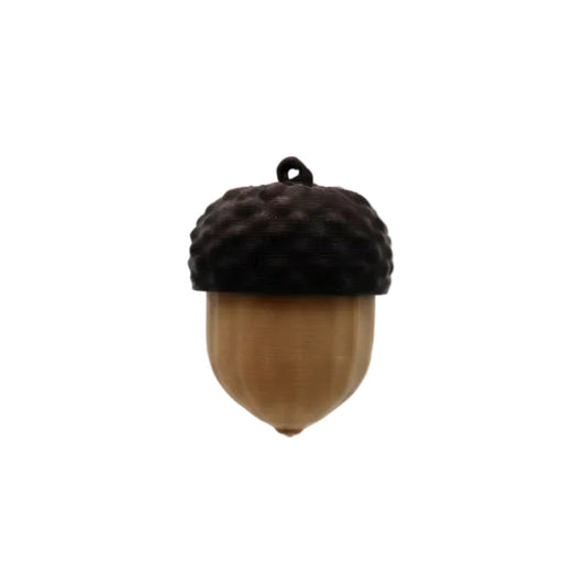 A hand with turquoise nail polish holds a small acorn-shaped fidget toy against a plain light gray background.