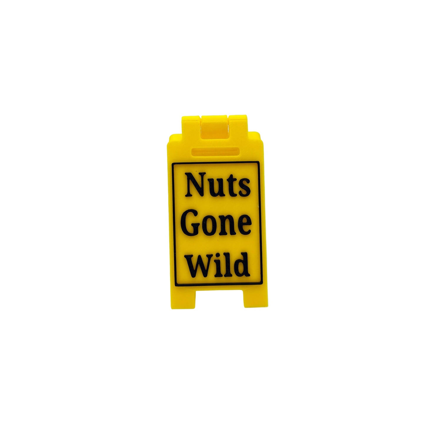 A small yellow plastic A-frame sign with black text reading 'Nuts Gone Wild' on a white studio background.