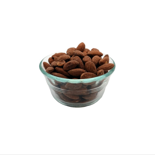 Salted Almonds in a small clear glass bowl on a white studio background.