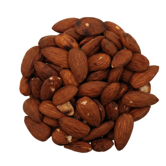 A clear glass bowl filled with whole unsalted almonds, photographed from above on a plain white background.