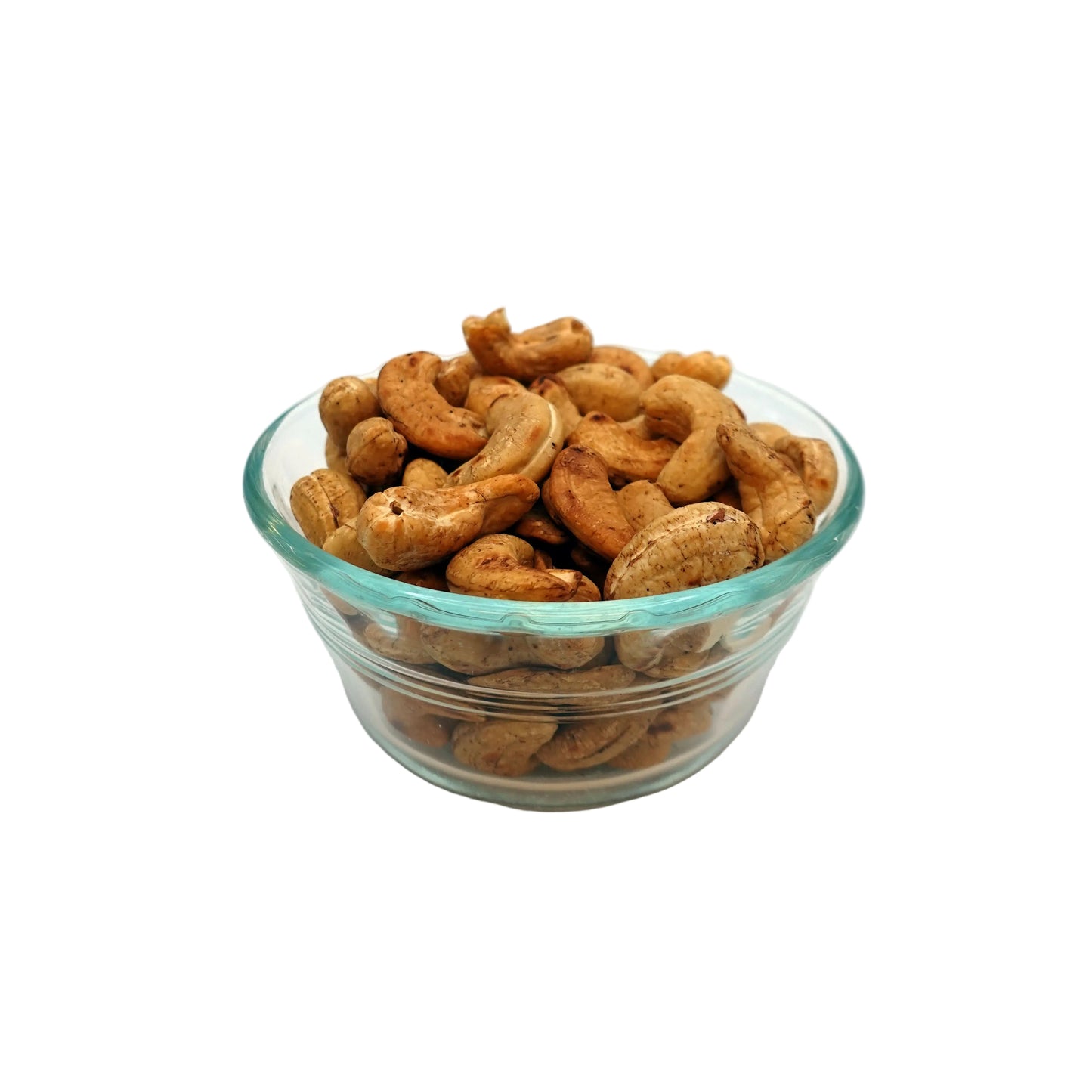 Roasted unsalted cashews in a small clear glass bowl, centered on a plain white studio background.