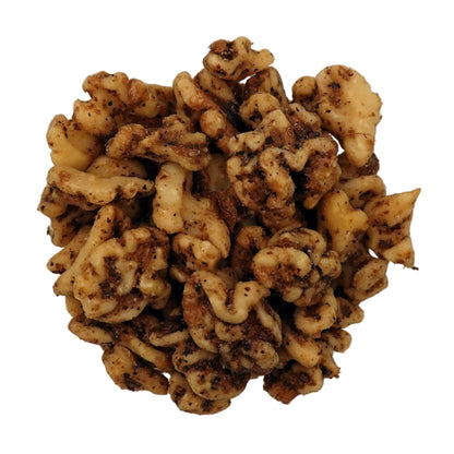 A top-down view of unsalted walnuts in a clear glass bowl on a plain white background.