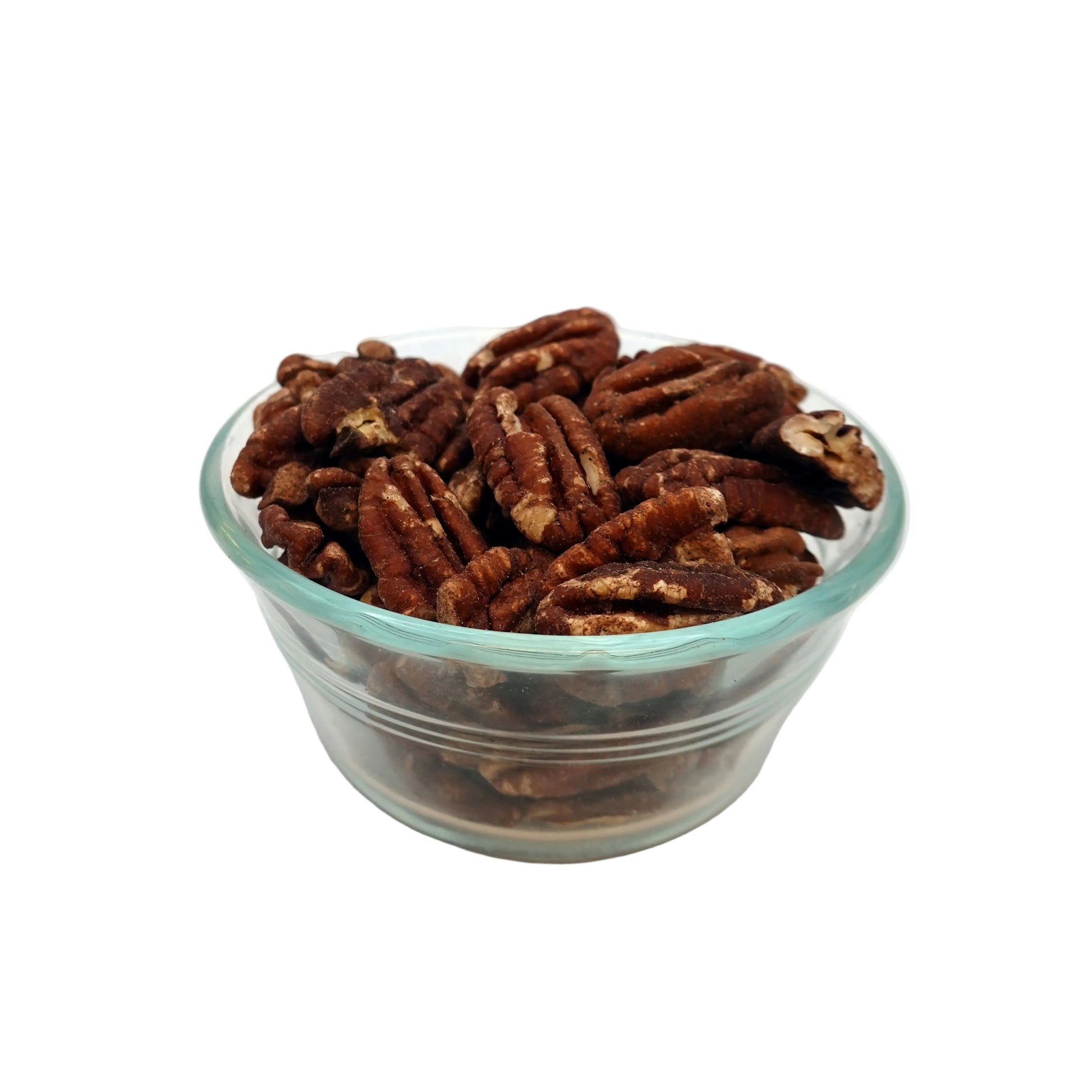 A clear glass bowl filled with brown salted pecans on a white studio background.