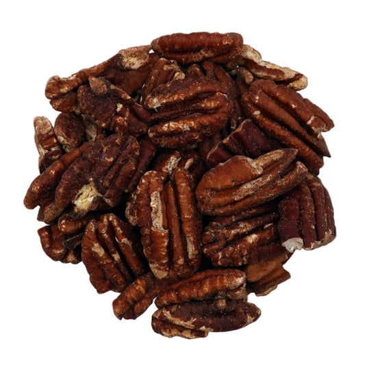A clear glass bowl filled with brown salted pecans, photographed from above on a plain white background.