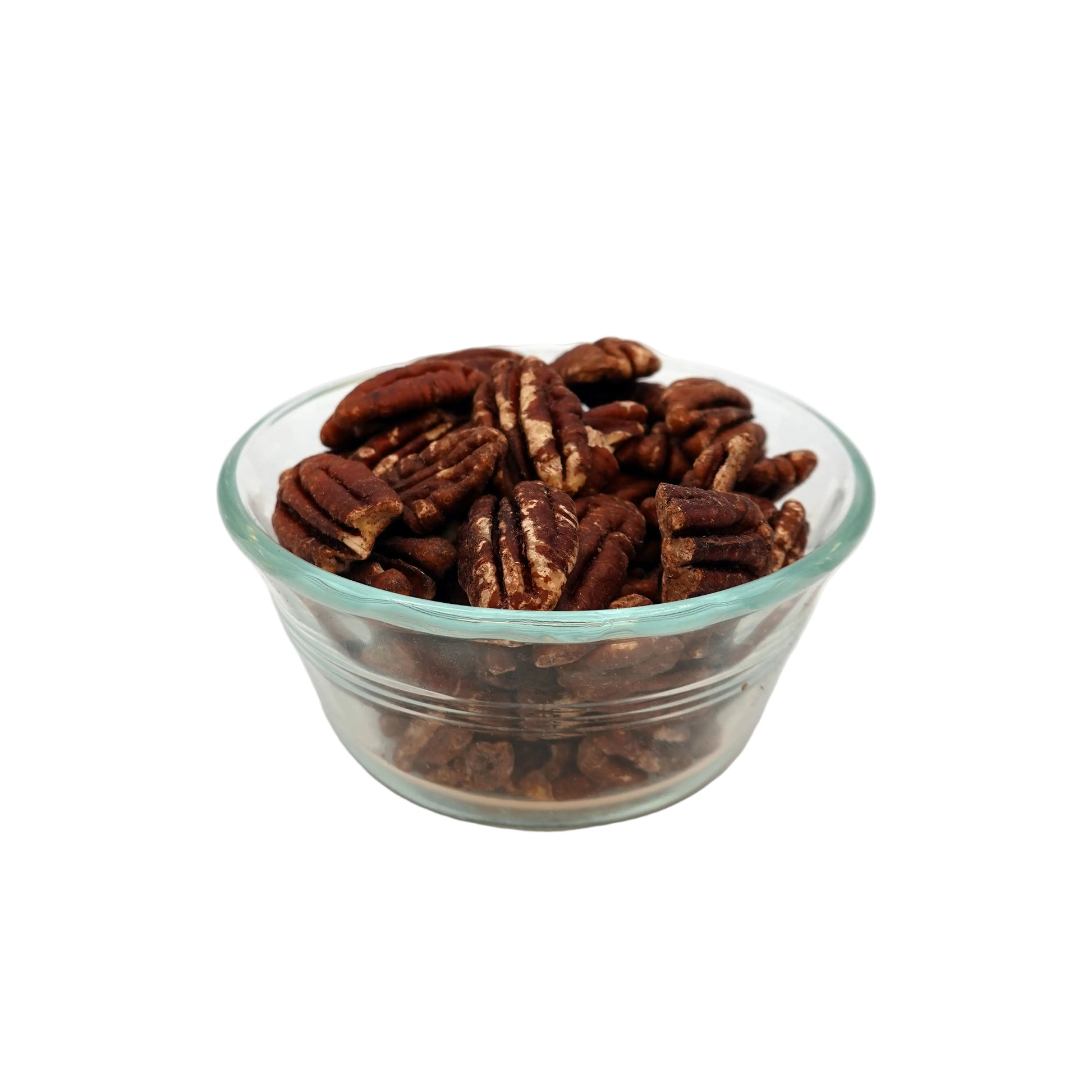 A clear glass bowl filled with unsalted pecans on a light gray studio background.