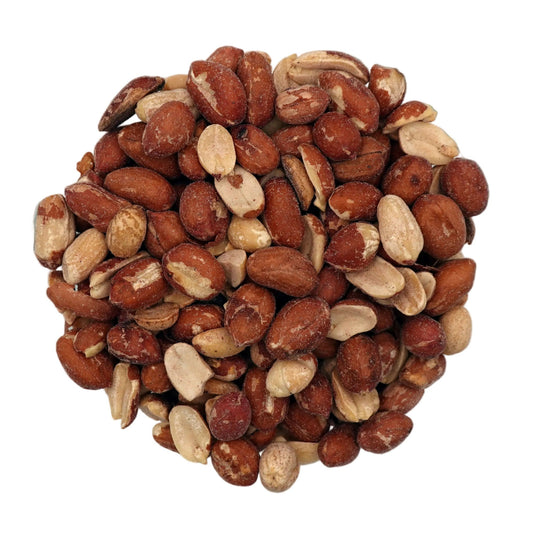 A clear glass bowl filled with roasted and salted spanish peanuts, photographed on a plain white studio background.
