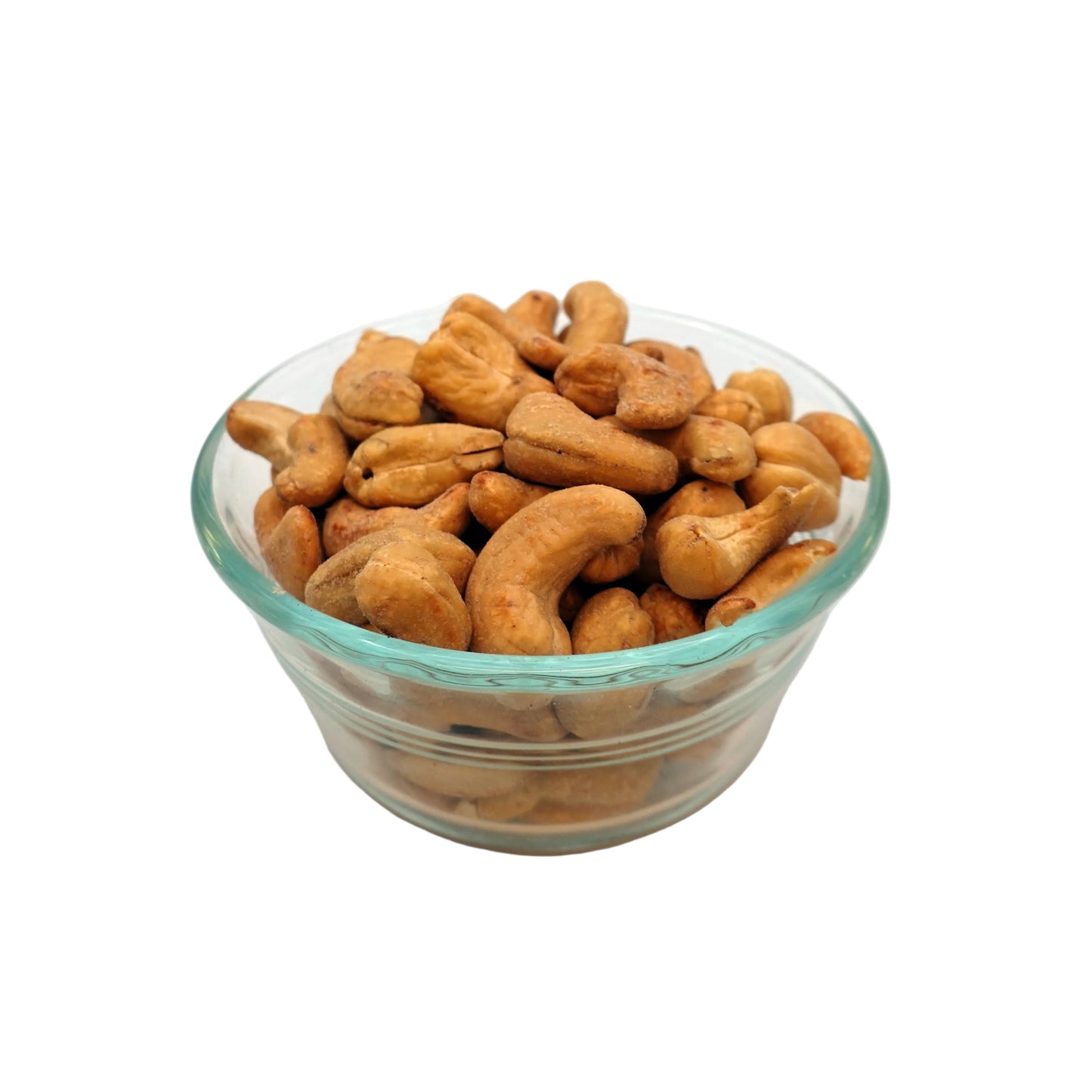 Salted cashews in a small clear glass bowl, photographed on a plain light gray to white studio background.