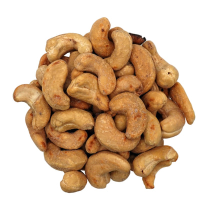 Salted cashews in a clear glass bowl, photographed from a top-down view on a plain white background.