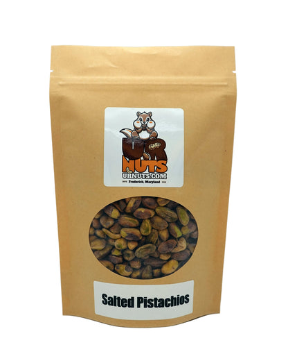 A stand-up kraft paper pouch of UR Nuts Gourmet's Salted Pistachios, featuring a clear window displaying the brown and green pistachio halves inside. The kraft bag has a white label with the UR Nuts Gourmet logo at the top and a white label at the bottom reading 'Salted Pistachios'.
