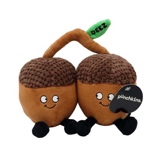 Two acorn-shaped plush toys with brown knit caps, smiling faces, black legs, and green stems labeled 'DEEZ'.