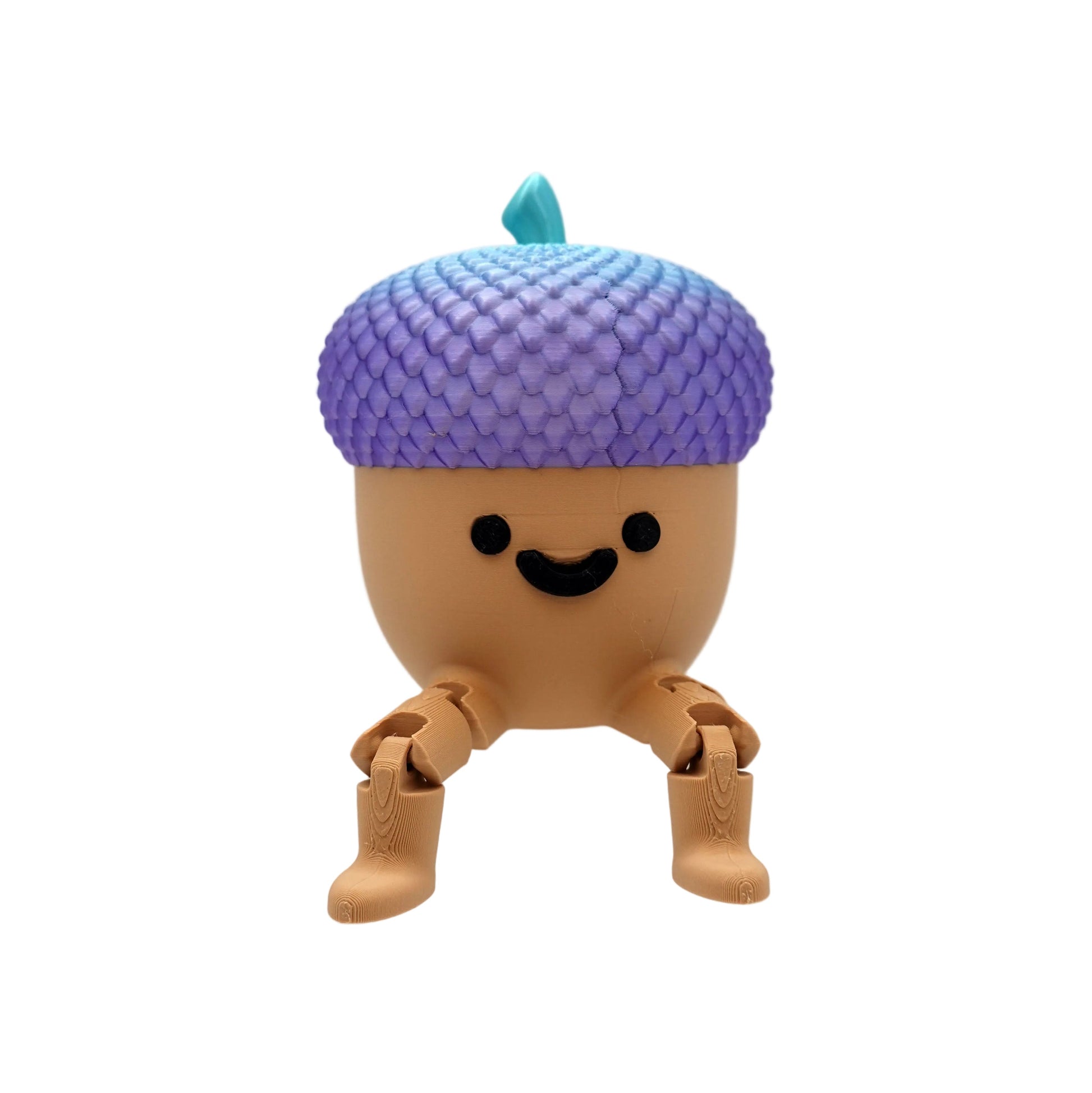 A cute, stylized acorn-shaped toy figure with a purple-to-blue gradient scaly cap, a small teal leaf, and a smiling face, sitting on a clear acrylic display block against a white studio background.