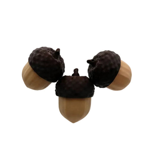 Three acorn-shaped fidget toys hovering against a plain light gray studio background.