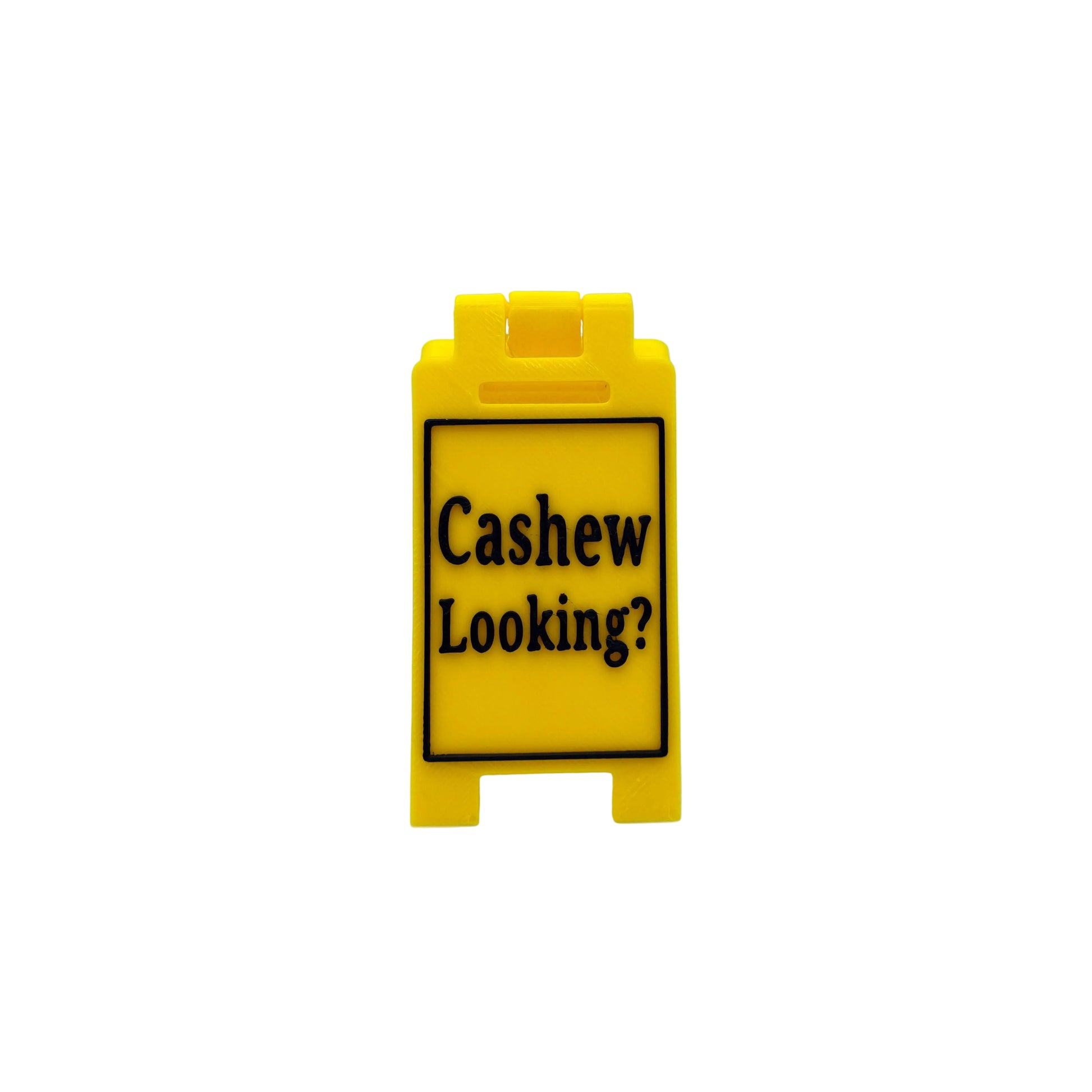 A small yellow plastic sign with black text reading 'Cashew Looking?' on a light gray background.