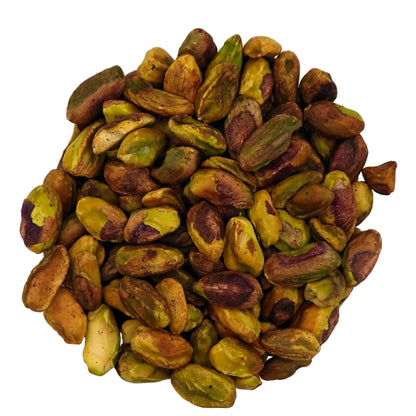 A clear glass bowl filled with unsalted pistachios, photographed from above on a plain white background.