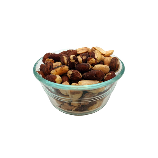 A small clear glass bowl filled with mixed nuts, including Salted Redskin Peanuts, photographed on a plain light gray studio background.