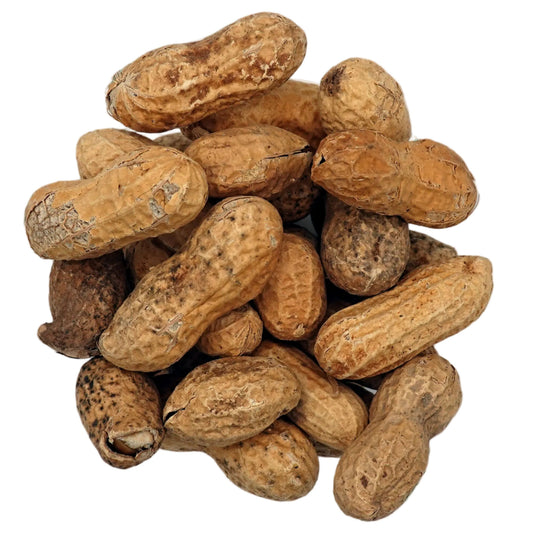 A top-down view of unsalted in-shell peanuts in their natural tan and brown shells, presented in a small clear glass bowl on a clean white background.