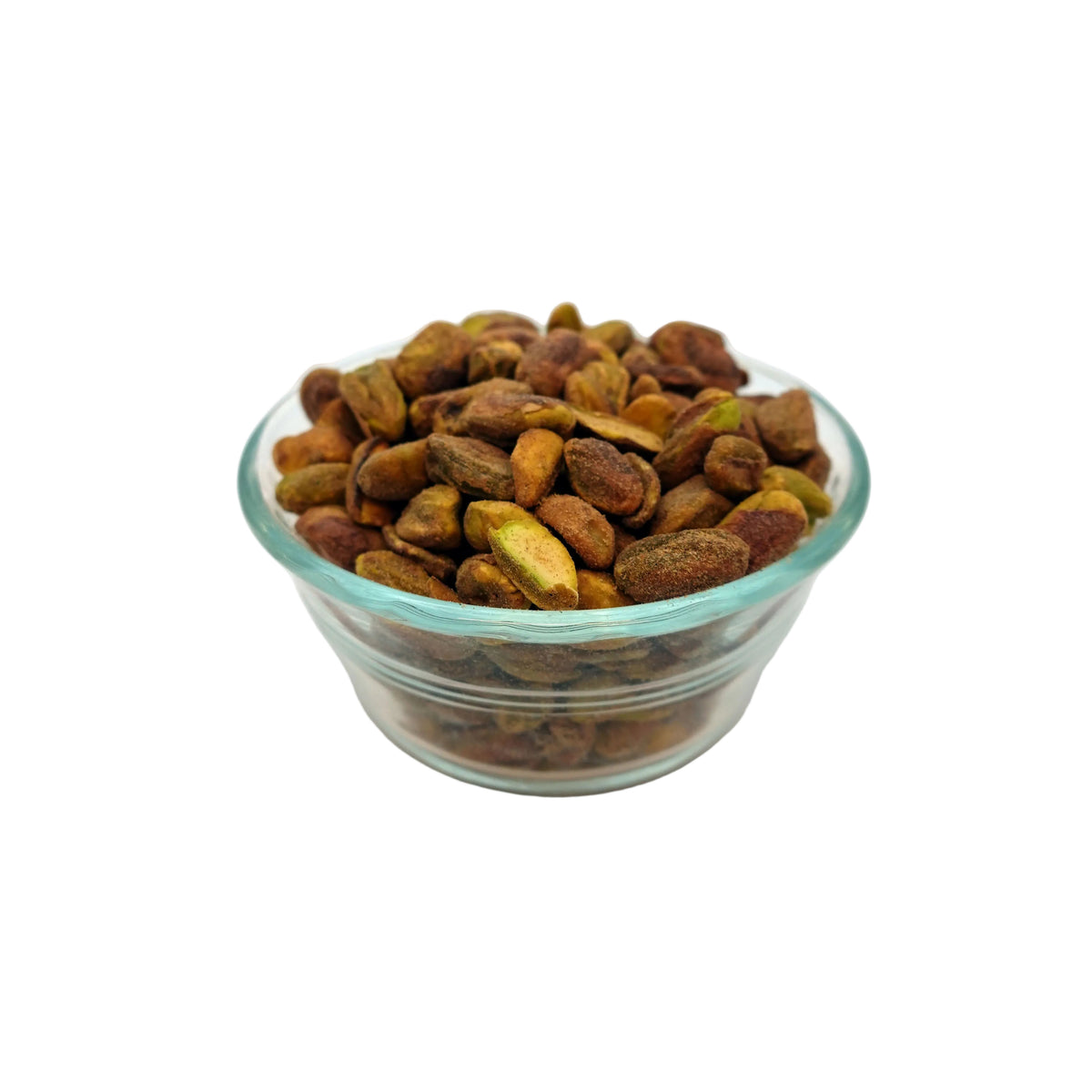 A small clear glass bowl filled with roasted pistachios on a white studio background.