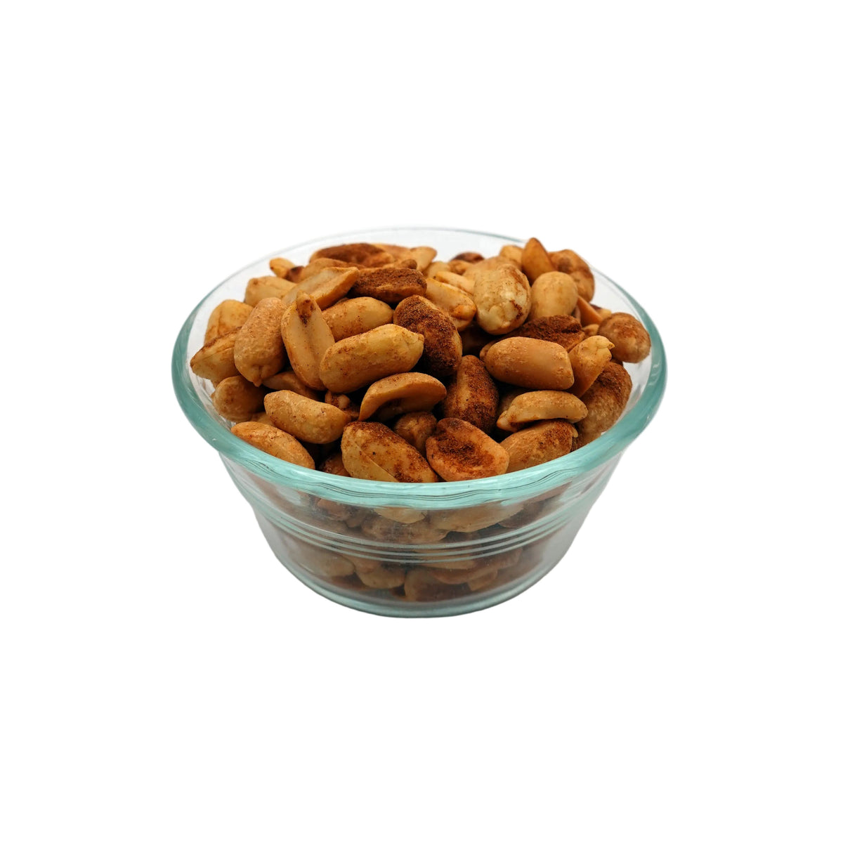 Roasted old bay cashews piled in a small clear glass bowl on a light gray studio background.
