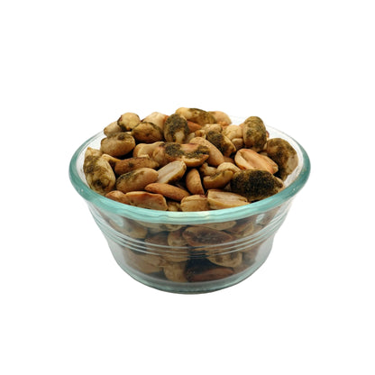 A top-down view of a clear glass bowl filled with Smoky Jalapeño Peanuts, on a plain white background.