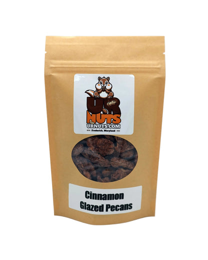A stand-up kraft paper pouch of UR Nuts Cinnamon Glazed Pecans, featuring a clear window that displays the glazed pecans inside. The packaging has a white label with the UR Nuts brand logo and product name.