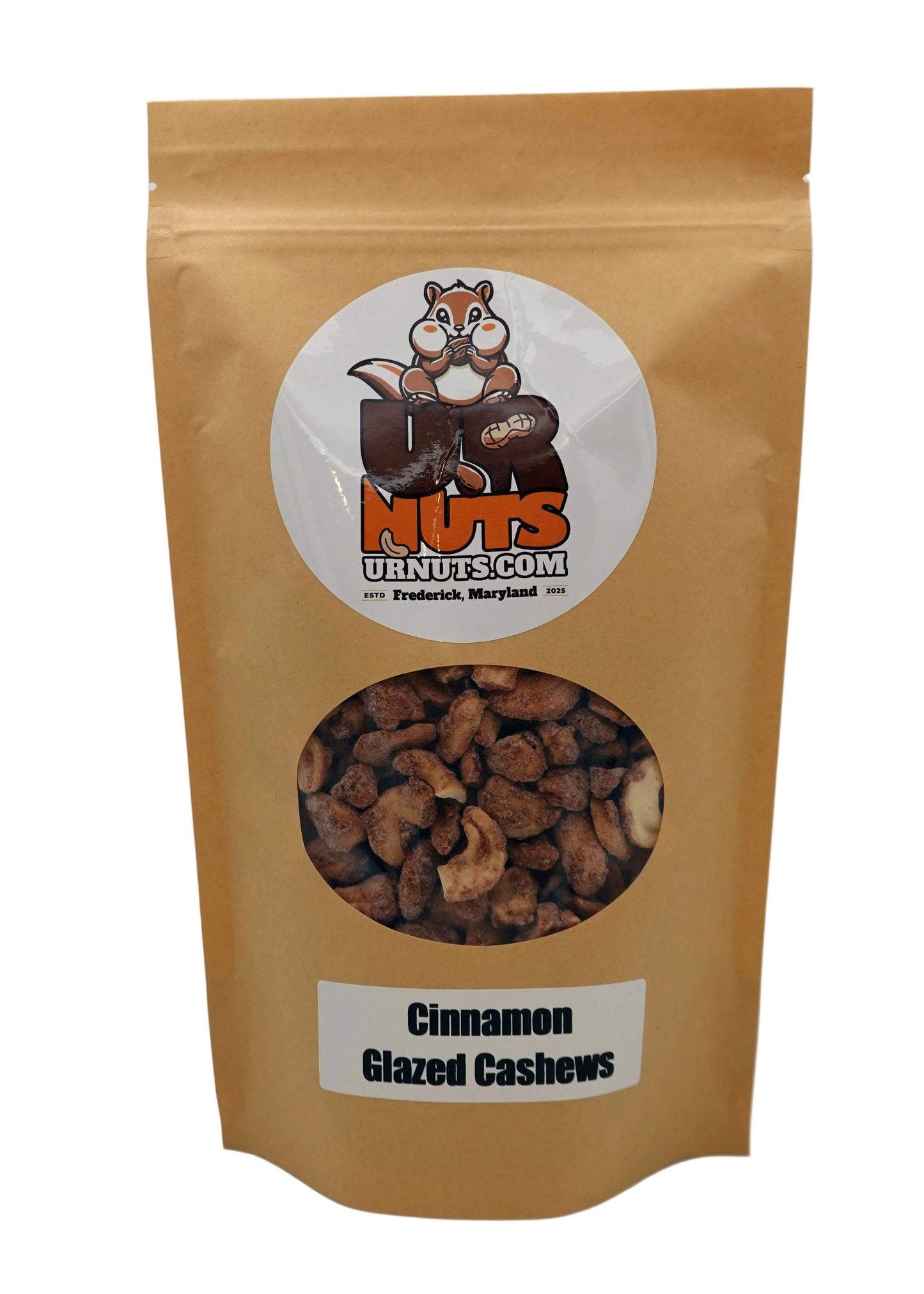 A stand-up kraft paper pouch of Cinnamon Glazed Cashews from UR Nuts, featuring a circular logo with a cartoon nut logo and a clear window showing the cashews inside.