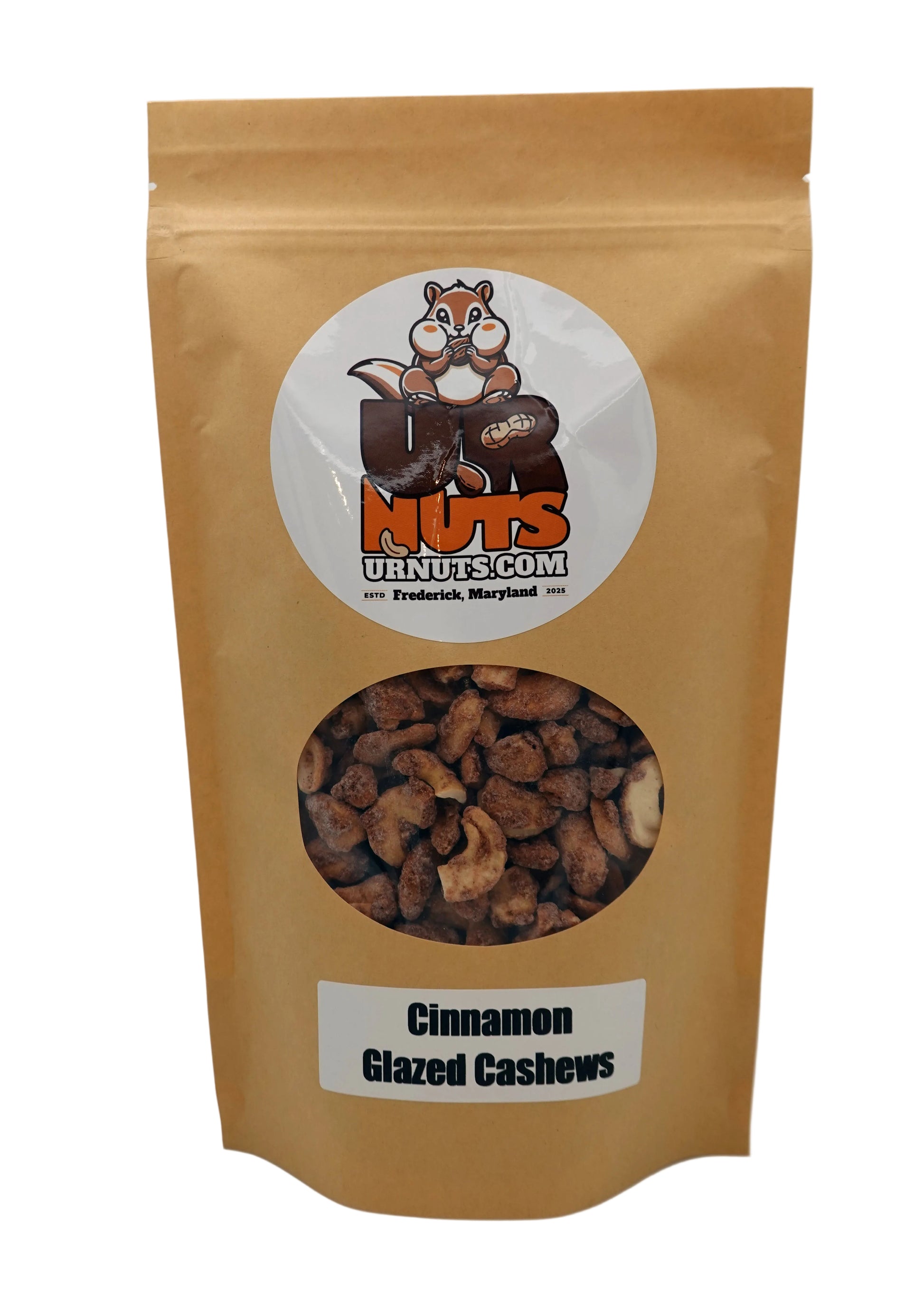 A stand-up kraft paper pouch of Cinnamon Glazed Cashews from UR Nuts, featuring a circular logo with a cartoon nut logo and a clear window showing the cashews inside.
