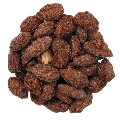 A clear glass bowl filled with brown cinnamon glazed almonds, photographed from a top-down view on a clean white background.