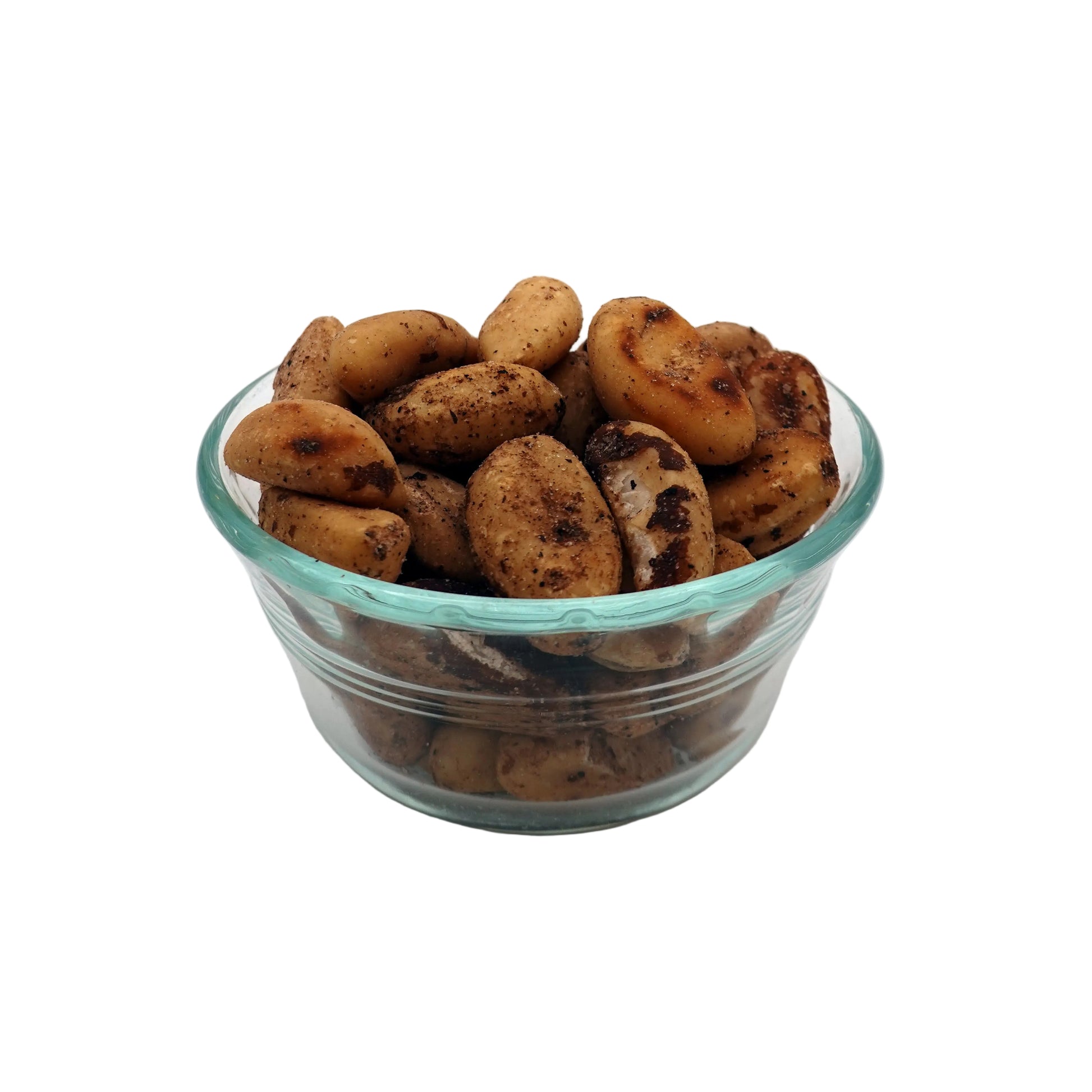 A small clear glass bowl filled with roasted and salted brazil nuts, photographed on a plain light gray to white studio background.