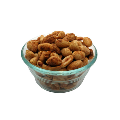 Roasted savory cajun peanuts in a small clear glass bowl, set against a seamless light gray studio background.