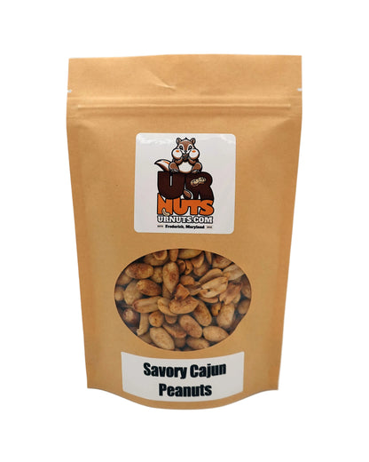 A stand-up kraft paper pouch of Savory Cajun Peanuts with a clear window showing the peanuts inside. The pouch features a white label with a cartoon nut logo for UR Nuts.