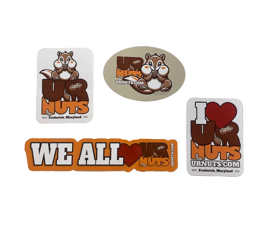 Four UR Nuts brand stickers featuring a cartoon chipmunk and the text 'We All NUTS' and 'I [heart] NUTS', displayed on a beige background.